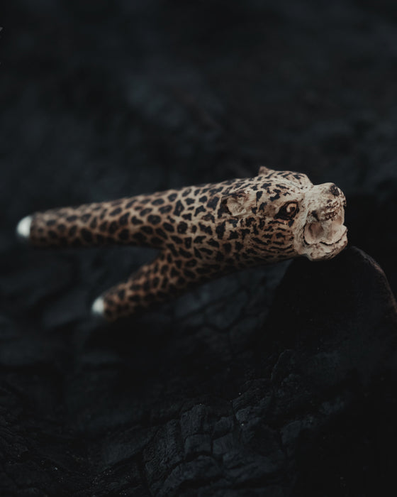 Leopard figurine on a dark textured surface