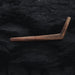 Wooden L-shaped tool on a dark textured surface