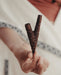 Hand holding a wooden y-shaped tool against a blurred background