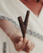 Hand holding a wooden slingshot with a blurred background