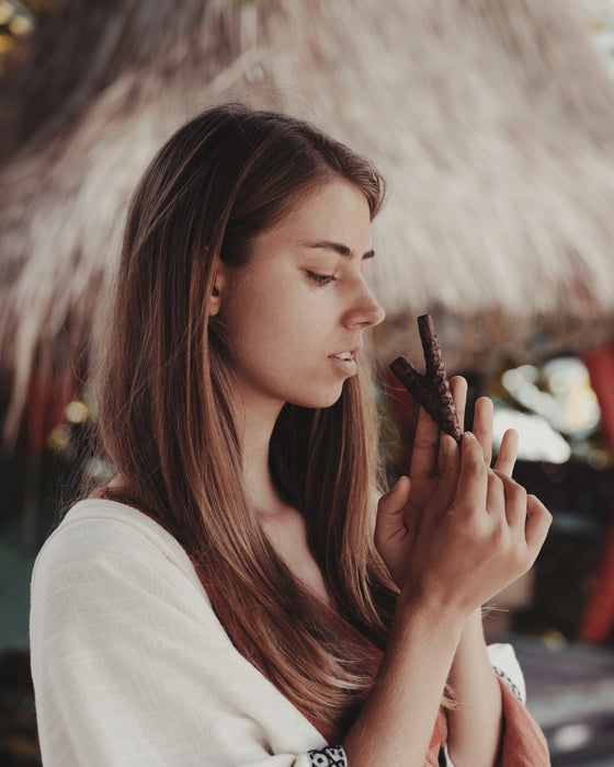 Woman holding a chocolate bar in front of a blurred background
