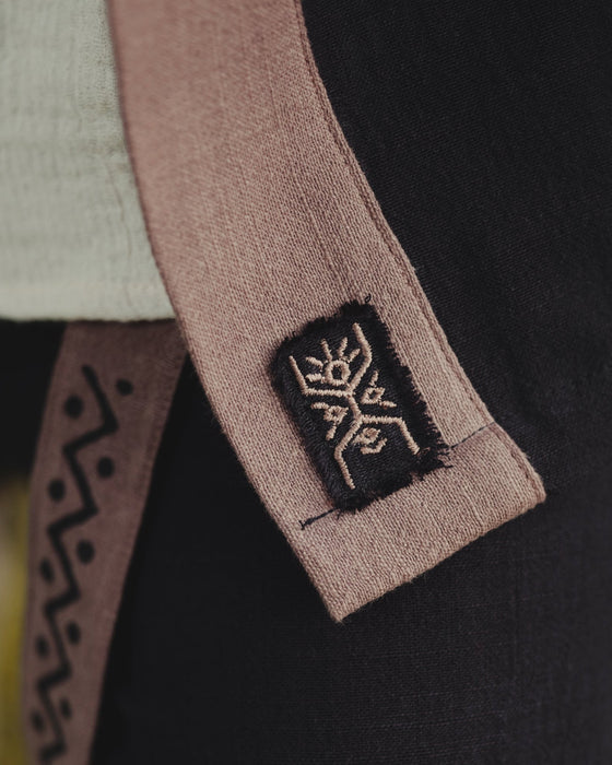 Close-up of a brown belt with a logo on a black garment, featuring the AYAGO brand.