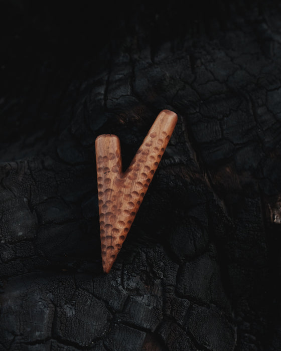 Wooden letter 'V' on a textured black background