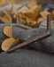 Wooden tool on a rock with autumn leaves in the background