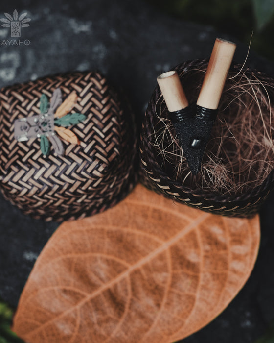 Two woven baskets with decorative elements on a leafy background