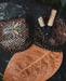 Two woven baskets with decorative elements on a leafy background