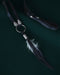 Black raven feather encased in resin with silver wire wrapping, hanging from a black leather choker for an edgy spiritual look