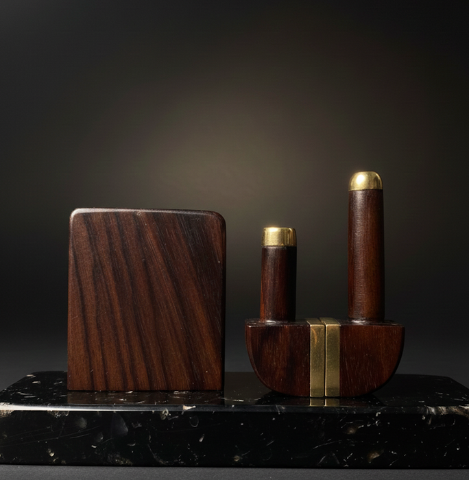 Wooden and brass objects on a dark marble surface with a dark background