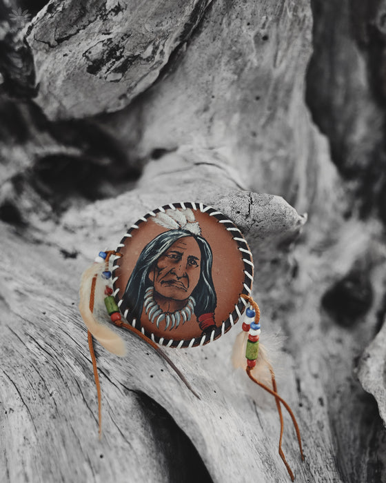 Delicate feather and bead brooch resembling a mini dreamcatcher, pinned to a lace shawl for festival-ready elegance