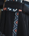 Close-up of a black garment with a patterned strap featuring triangles and lines.