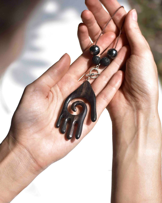 Empower your spirit with our Sacred Ebony Wood Amulet Necklace, adorned with Hematite and volcanic lava for protection and grounding. Handcrafted for beauty and spiritual reinforcement.