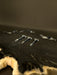 Close-up of a guitar's headstock with tuning pegs on a dark background