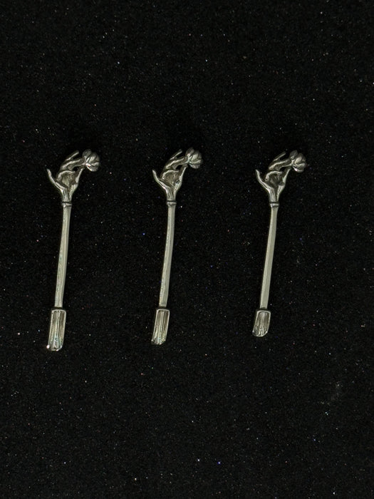 Three metallic hair accessories with decorative elements on a black background