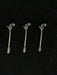 Three metallic hair accessories with decorative elements on a black background