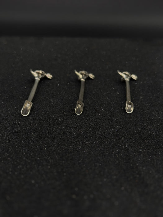 Three small metal objects on a black textured surface