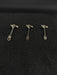 Three small metal objects on a black textured surface