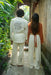 Two people standing together outdoors, wearing matching outfits with embroidered designs.