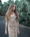 A woman gracefully descends steps in a handmade boho maxi dress with fringe detailing, perfect for bohemian festivals or a boho wedding, embodying a romantic and ethereal goddess vibe