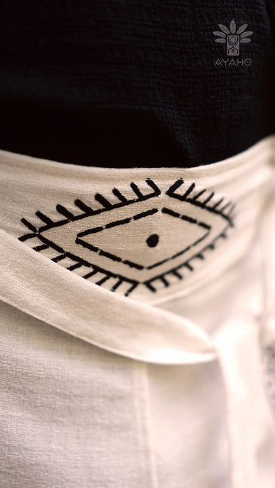 Close-up of a white garment with black geometric design, featuring the brand 'AYAHO'.