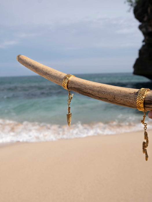 Gold earrings on a stick with a beach background
