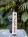Palo Santo Incense Stick on a stone surface with a blurred green leafy background