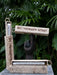 Three wooden incense holders with 'Palosanto Retreat' branding against a green leafy background.