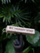 Palosanto retrogat incense stick held by a statue hand with green foliage in the background