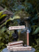 Miniature smoking device with smoke and text on a blurred natural background