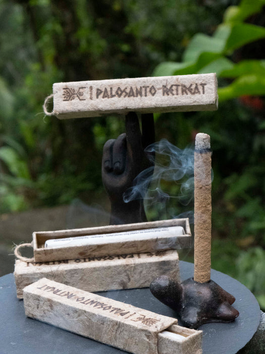 Palosanto retreat incense holder with smoke against a blurred green background
