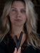 Woman holding a wooden V-shaped object with a blurred background