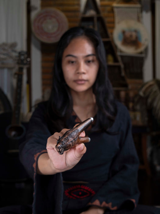 Person holding a small object in a blurred indoor setting