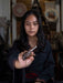 Person holding a small object in a blurred indoor setting