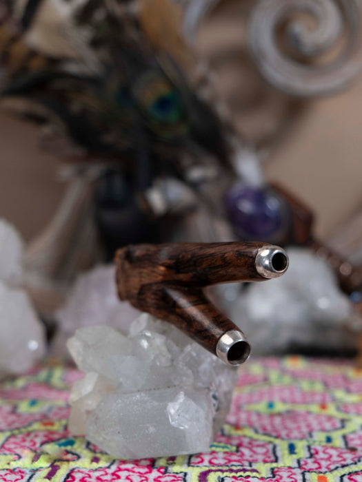 Wooden and metal pipe on a crystal base with a colorful fabric background