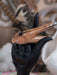 Decorative object with a black hand holding a wooden stick against a blurred background