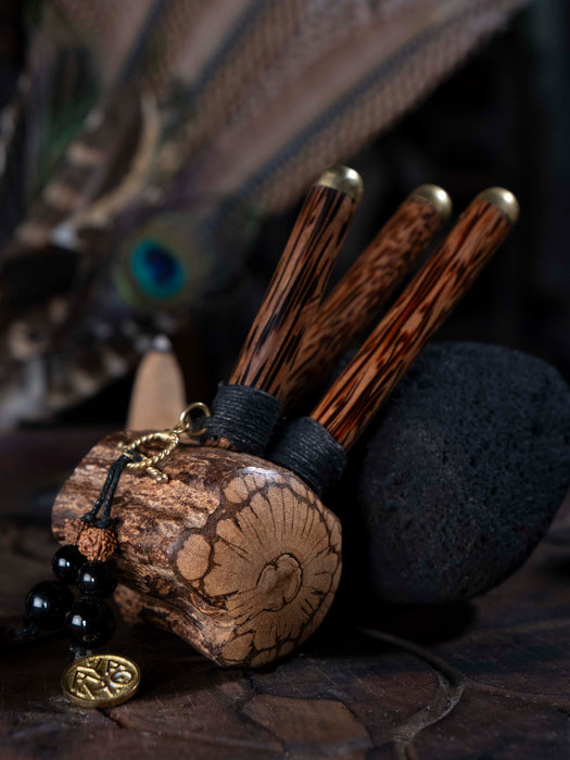 Wooden tool with a textured handle and decorative elements on a dark background