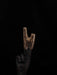 Hand holding a wooden tool against a black background