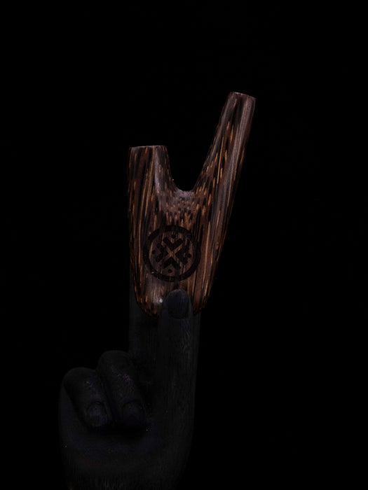 Wooden product with a symbol held by a gloved hand against a black background