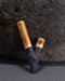 Two wooden and black decorative items on a dark textured surface