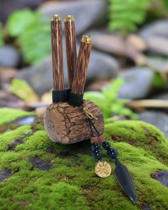 Wooden pipe with gold accents on a green mossy surface