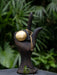 Decorative object with a gold sphere and chain on a dark background