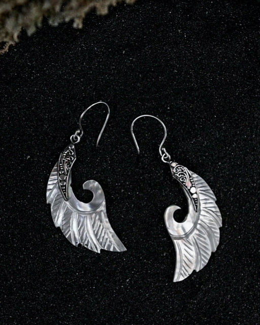 Exquisite Angel Wings earrings, crafted from lustrous mother-of-pearl and detailed sterling silver, radiating aesthetic grace and ethereal charm