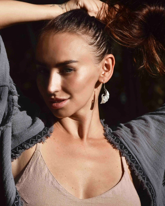 Exquisite Angel Wings earrings, crafted from lustrous mother-of-pearl and detailed sterling silver, radiating aesthetic grace and ethereal charm