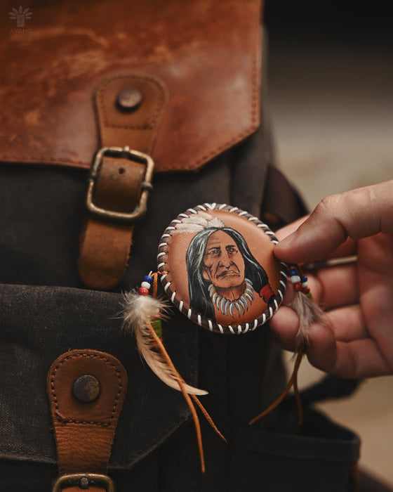 Striking eagle feather brooch with copper wire accents, photographed against pine branches for a forest-themed aesthetic.