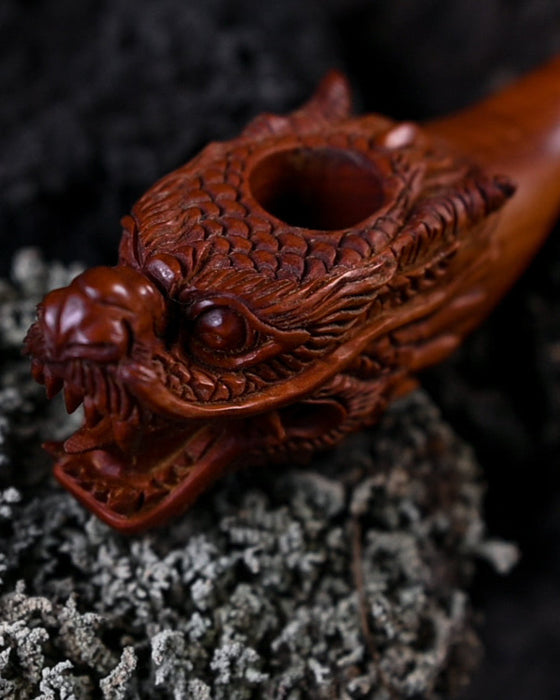 Handcrafted wood smoking pipe with elegant dragon carvings, combining quality and artistic flair.