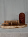 Temple incense with a wooden sculpture on a stone platform against a gray background