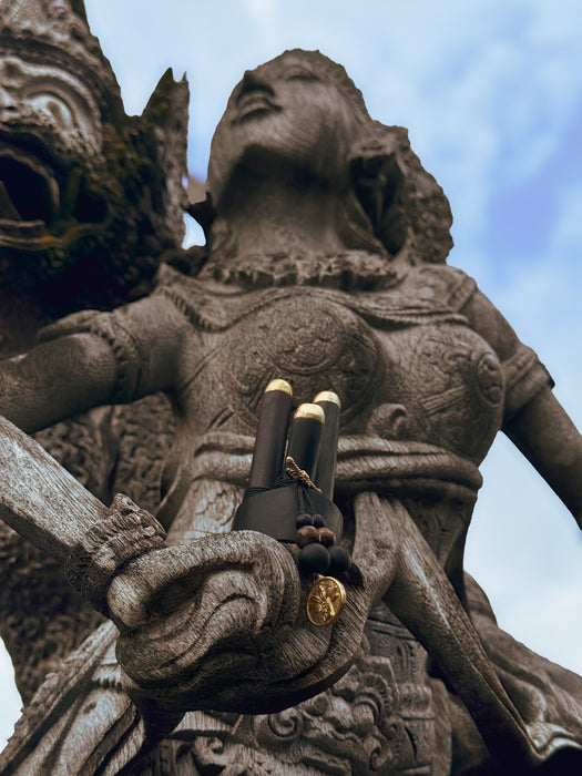 Close-up of a stone statue with intricate details against a blue sky.