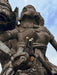 Close-up of a stone statue with intricate details against a blue sky.