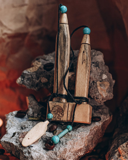 Hand-carved tamarind wood pipe with traditional Shipibo patterns and turquoise inlay, resting on ceremonial cloth