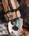 Hand-carved tamarind wood pipe with traditional Shipibo patterns and turquoise inlay, resting on ceremonial cloth