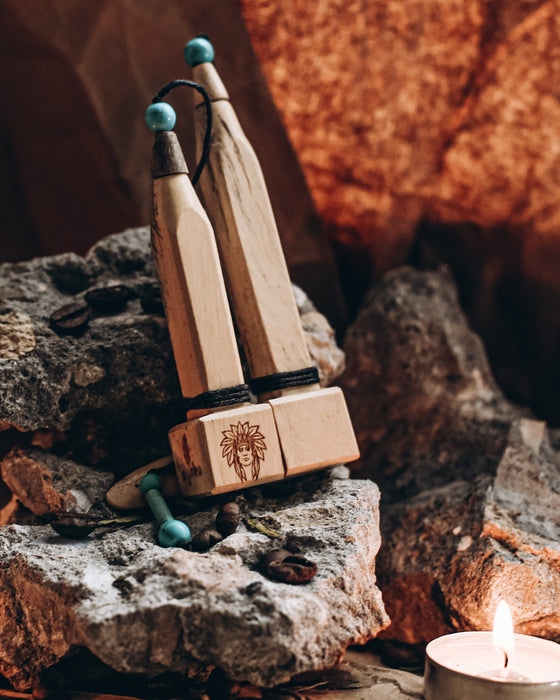 Hand-carved tamarind wood pipe with traditional Shipibo patterns and turquoise inlay, resting on ceremonial cloth
